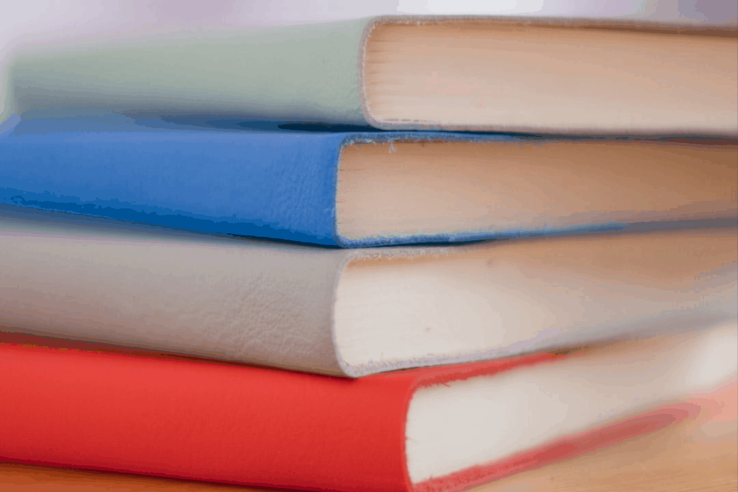 Stack of multi-colored books for a blog post about building trust through storytelling
